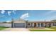 Charming one-story home featuring a gray two-car garage and an arched walkway to the front door at 140 88Th Ne Ave, St Petersburg, FL 33702