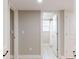 Hallway view featuring neutral walls leading to the bathroom with ample lighting at 140 88Th Ne Ave, St Petersburg, FL 33702