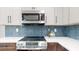 Close-up view of a modern kitchen featuring stainless steel appliances and a stylish backsplash at 140 88Th Ne Ave, St Petersburg, FL 33702