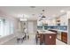 Bright kitchen and dining area featuring an island with seating, stainless steel appliances, and modern lighting at 140 88Th Ne Ave, St Petersburg, FL 33702