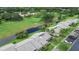 Scenic aerial view of a condo complex backing onto a lush green golf course with mature trees and serene pond at 140 Dale Pl, Oldsmar, FL 34677