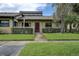 Inviting front of home with well-manicured lawn, mature landscaping, and shaded walkway at 140 Dale Pl, Oldsmar, FL 34677