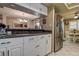 Open kitchen with white cabinets, stainless steel refrigerator, and a view of the breakfast nook at 140 Dale Pl, Oldsmar, FL 34677