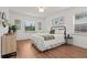 Sunlit bedroom with hardwood floors, white bedding, and an inviting atmosphere at 1743 Fulton Ave, Clearwater, FL 33755