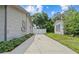 Long concrete driveway leading to a white gate and separate building alongside the house at 1743 Fulton Ave, Clearwater, FL 33755