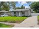 Well-maintained home with a green lawn and long driveway, showcasing curb appeal at 1743 Fulton Ave, Clearwater, FL 33755