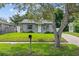Quaint home with a green lawn and mature tree, enhancing curb appeal at 1743 Fulton Ave, Clearwater, FL 33755