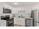 Modern kitchen with stainless appliances, white cabinets and marble countertops at 1743 Fulton Ave, Clearwater, FL 33755