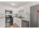 Updated kitchen featuring stainless steel appliances, marble countertops, and white cabinets at 1743 Fulton Ave, Clearwater, FL 33755