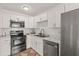 Modern kitchen featuring stainless steel appliances, white cabinets and marble countertops at 1743 Fulton Ave, Clearwater, FL 33755