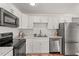 A modern kitchen featuring stainless steel appliances, white cabinets and marble countertops at 1743 Fulton Ave, Clearwater, FL 33755