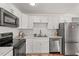 Bright kitchen with stainless steel appliances, marble countertops, and white cabinetry at 1743 Fulton Ave, Clearwater, FL 33755