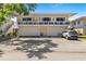 Two-story condo with a balcony above three garage doors, and ample parking space on a sunny day at 1813 Bough Ave # B, Clearwater, FL 33760