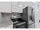 Modern kitchen showcasing white cabinets, granite countertops, and stainless steel appliances at 1813 Bough Ave # B, Clearwater, FL 33760