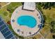 Aerial view of a kidney-shaped pool with lounge chairs and tables surrounded by lush landscaping and greenery at 1813 Bough Ave # B, Clearwater, FL 33760