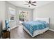Inviting bedroom with wood floors, ceiling fan, and sliding glass doors that lead to an outdoor space at 19113 Golden Cacoon Pl, Lutz, FL 33558