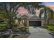 Charming single-story home featuring a well-manicured lawn, mature trees, and a two-car garage at 19113 Golden Cacoon Pl, Lutz, FL 33558