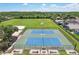 Overhead view of tennis courts and fenced in field with trees in Landora community at 19113 Golden Cacoon Pl, Lutz, FL 33558
