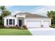 Attractive one-story home featuring a three-car garage, well-manicured lawn, and stone veneer accents at 19707 Gladeview Way, Land O Lakes, FL 34638