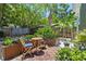 Relaxing backyard with wood-tiled patio, lush planters, and charming outdoor furniture at 2026 Union S St, St Petersburg, FL 33712