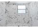 Walk-in shower showcasing marble tile walls and mosaic tile floor with a modern shower head at 2026 Union S St, St Petersburg, FL 33712