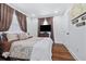 Bedroom with hardwood floors, neutral bedding, large windows and TV on dresser at 2026 Union S St, St Petersburg, FL 33712
