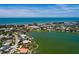 Aerial view showcasing waterfront properties with dock access, lush landscaping, and close beach proximity at 208 Bath Club N Blvd, North Redington Beach, FL 33708