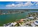 Wide aerial view showing the waterfront property with mature trees and a private boat dock at 208 Bath Club N Blvd, North Redington Beach, FL 33708