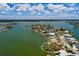 Stunning aerial view of waterfront home, featuring a private dock and lush landscaping at 208 Bath Club N Blvd, North Redington Beach, FL 33708
