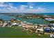 Expansive aerial view of waterfront homes with a dock, with lush landscaping near the bay at 208 Bath Club N Blvd, North Redington Beach, FL 33708