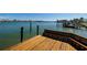 Close up of a wooden dock overlooking tranquil water and neighboring boat docks at 208 Bath Club N Blvd, North Redington Beach, FL 33708