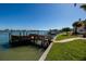 Waterfront view highlighting the wooden dock, waterfront access, and neighborhood at 208 Bath Club N Blvd, North Redington Beach, FL 33708