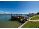Waterfront view showcasing the wooden dock, boat lift, and picturesque neighborhood at 208 Bath Club N Blvd, North Redington Beach, FL 33708