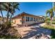 Single-story home with tile roof, brick-paved driveway, and tropical landscaping needs repair at 208 Bath Club N Blvd, North Redington Beach, FL 33708
