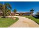 Welcoming single-story home with lush landscaping, mature palm trees, and a well-maintained front yard at 208 Bath Club N Blvd, North Redington Beach, FL 33708