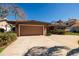 Attached two-car garage with a wide driveway and lush landscaping creating great curb appeal at 208 Bath Club N Blvd, North Redington Beach, FL 33708