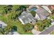 Aerial view of the home's roof, pool, surrounding greenery, and neighborhood at 2182 Trevor Rd, Palm Harbor, FL 34683
