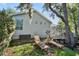 The backyard features lawn chairs, mature trees, and access to the enclosed patio at 2182 Trevor Rd, Palm Harbor, FL 34683