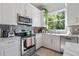Bright and airy kitchen with white cabinets, marble countertops, and stainless steel appliances at 2182 Trevor Rd, Palm Harbor, FL 34683