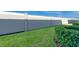 A view of a fenced in backyard with grass and neatly trimmed bushes at 2507 Arbor Wind Dr, Lutz, FL 33558