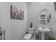 Cozy bathroom with an elegant rounded mirror and a pedestal sink with modern fixtures at 2507 Arbor Wind Dr, Lutz, FL 33558