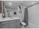 Well-lit bathroom featuring a tub and shower combo, gray vanity, and modern fixtures at 2507 Arbor Wind Dr, Lutz, FL 33558