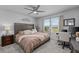 Bright bedroom featuring a large bed, ceiling fan, ample natural light, and a dedicated workspace at 2507 Arbor Wind Dr, Lutz, FL 33558