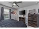 Bedroom featuring dark bedding, ceiling fan, dresser and natural lighting from the window at 2507 Arbor Wind Dr, Lutz, FL 33558