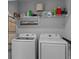 Bright laundry room features Samsung washer and dryer, with shelf storage above at 2507 Arbor Wind Dr, Lutz, FL 33558