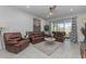 Comfortable living room with plush leather seating, tile floors, and a ceiling fan at 2507 Arbor Wind Dr, Lutz, FL 33558