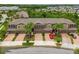 A picturesque aerial view of townhomes featuring brick driveways, lush landscaping, and a red car at 28568 Tranquil Lake Cir, Wesley Chapel, FL 33543