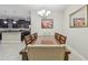 Spacious dining room showcasing a long wooden table, decorative artwork, and kitchen access at 28568 Tranquil Lake Cir, Wesley Chapel, FL 33543