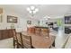 Open dining room with modern chandelier flows into the living space and kitchen at 28568 Tranquil Lake Cir, Wesley Chapel, FL 33543