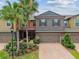 Charming two-story townhome with a well-maintained brick driveway and lush landscaping at 28568 Tranquil Lake Cir, Wesley Chapel, FL 33543